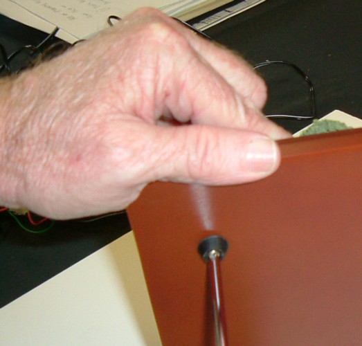 Removing the screws from the Wood Base which holds the Sculpture